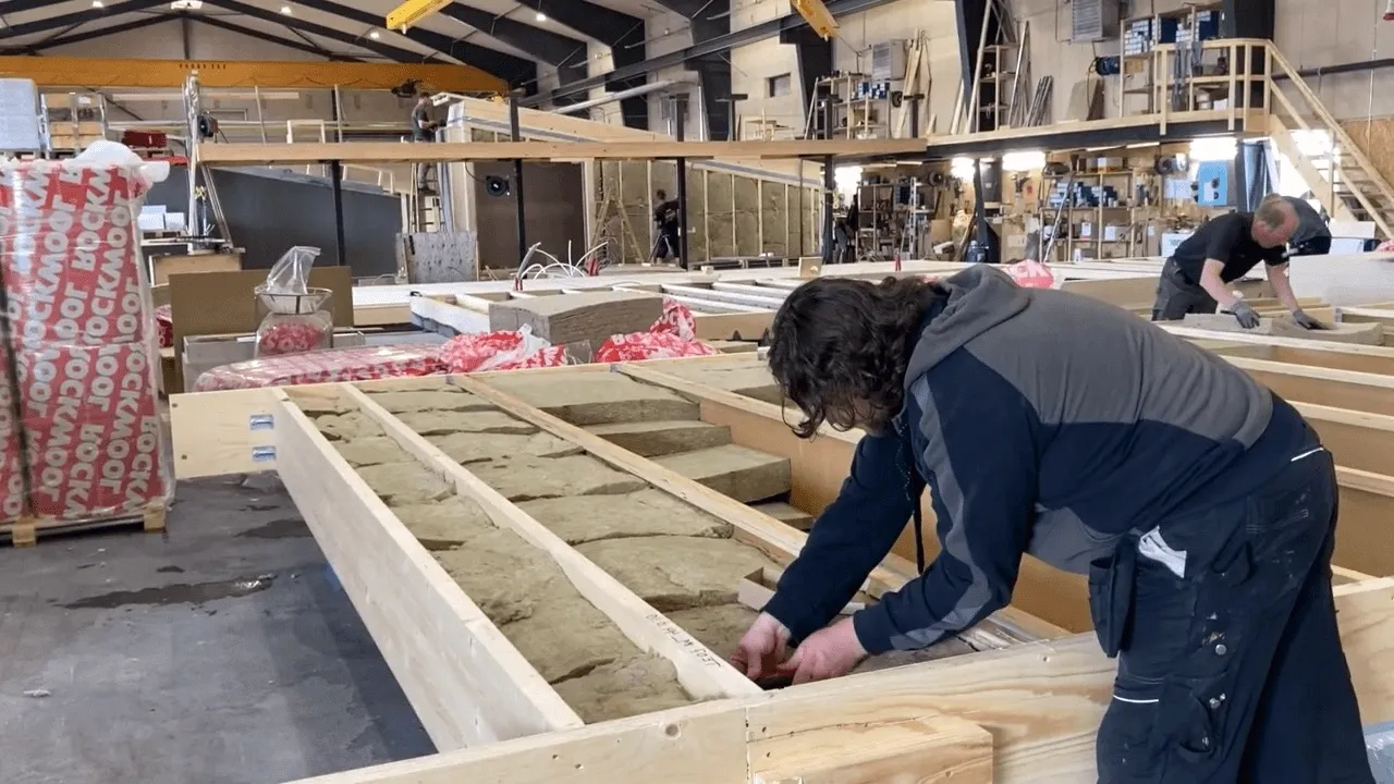 person installing wood sensor on timber in factory